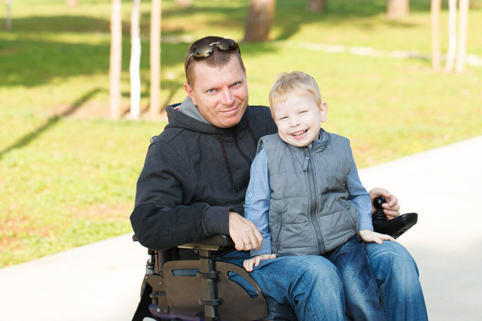 man with long term disability insurance at the park with his son